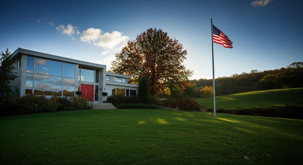 An American flag flying on a BlackForge flagpole beside a home